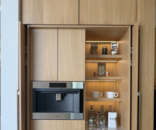 Integrated coffee station in rift cut oak, a built-in coffee maker, and illuminated shelves to display your cups and accessories